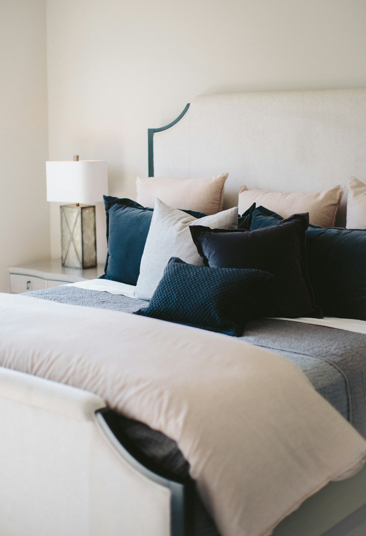 Black and white throw pillows arranged on a white bed