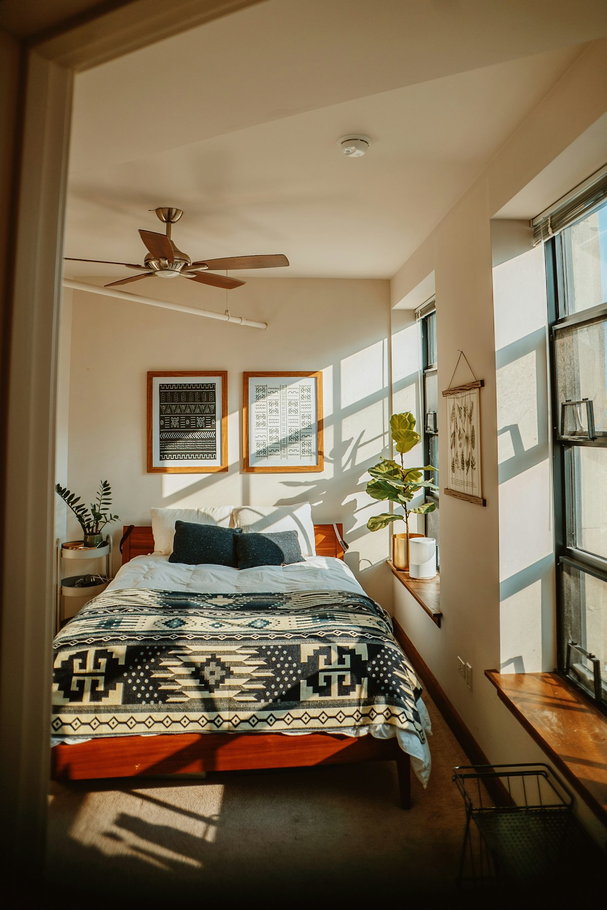Sunlit bedroom with a patterned quilt on the bed